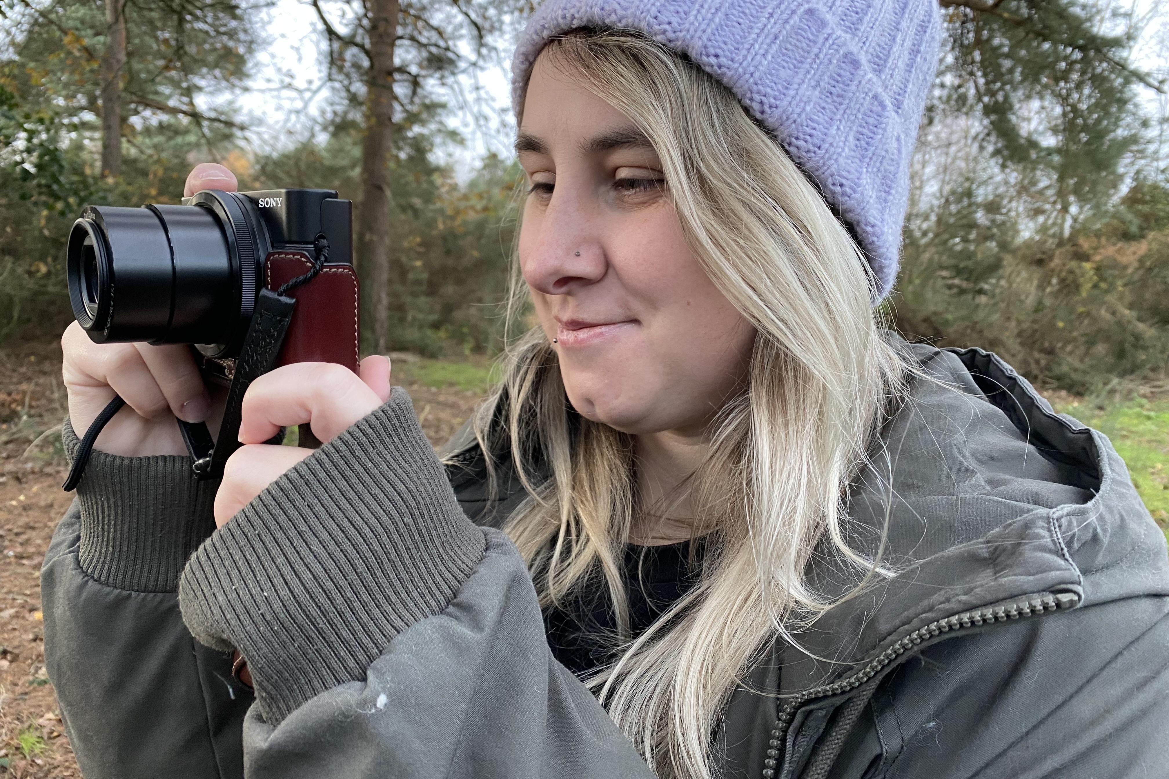 Jess in a forest holding a camera