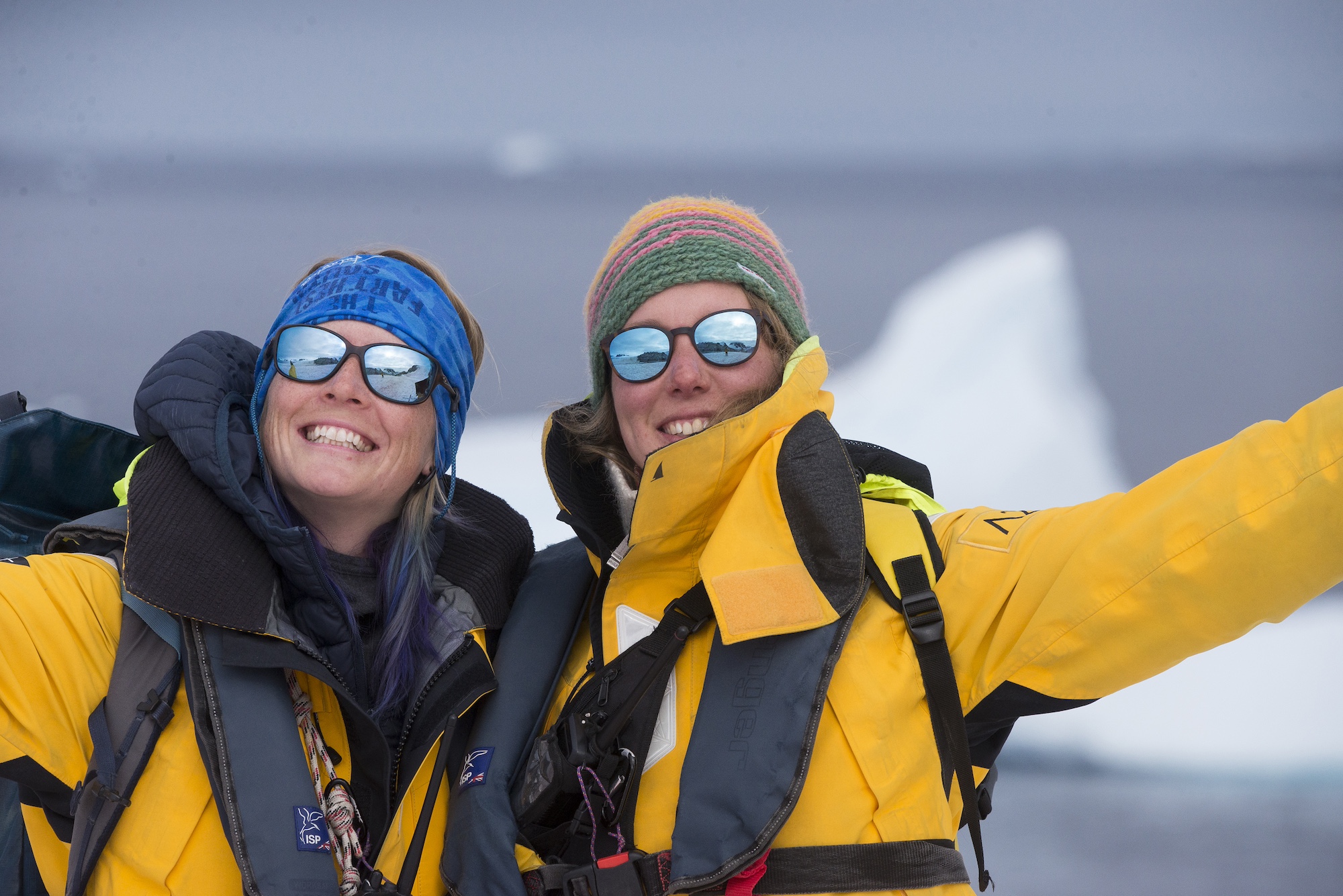 Two guides smile at the camera in Antarctica 