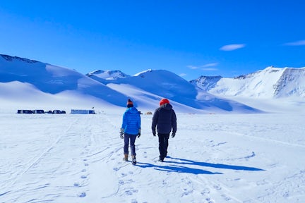 Tourists walking at Three Glaciers Retreat in the Antarctic Interior