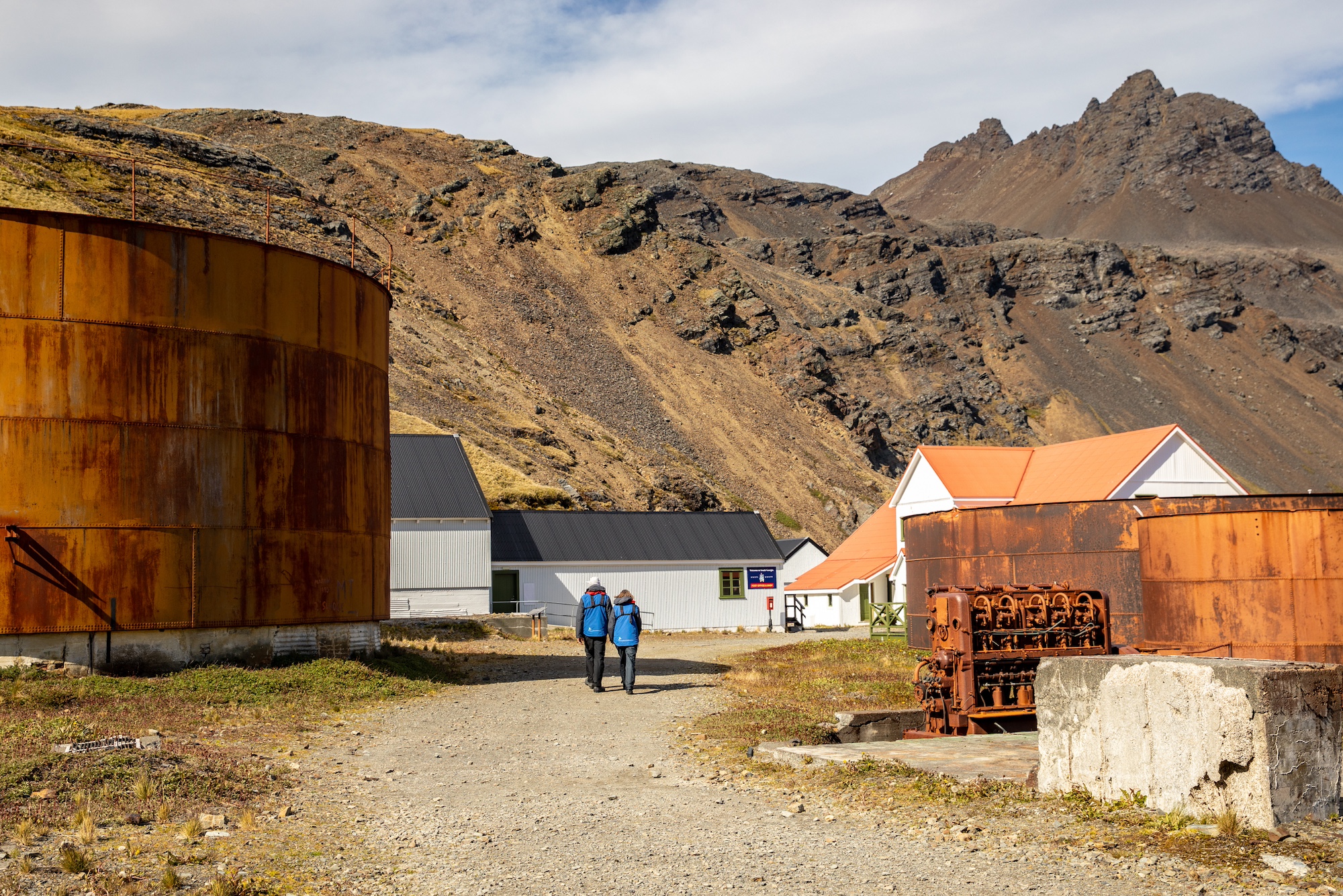 Two people explore Grytviken whaling station, South Georgia