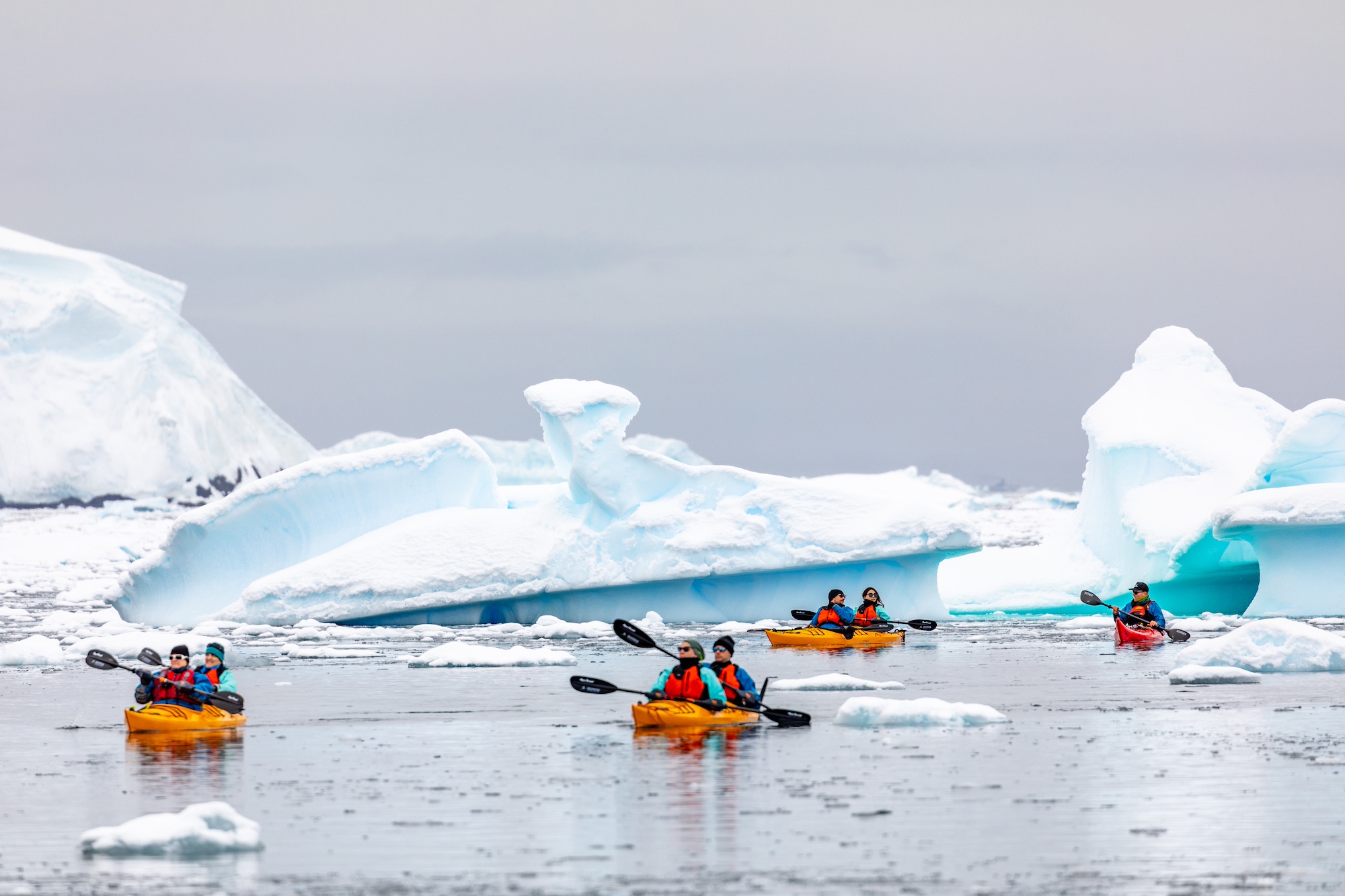 Travellers kayak in Wilhelmina Bay, Antarctica, around chunks of ice