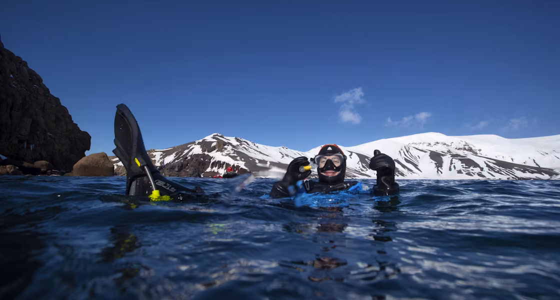 A man gives a thumbs up while snorkelling in Antarctica 
