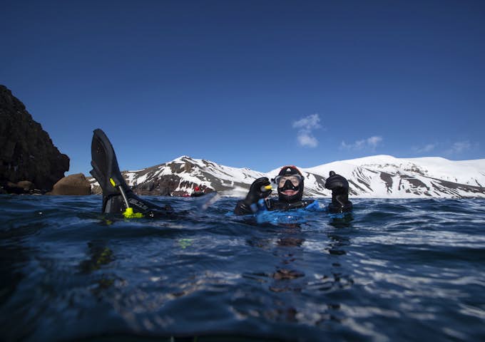 Snorkeller gives a thumbs up while in the Antarctic waters