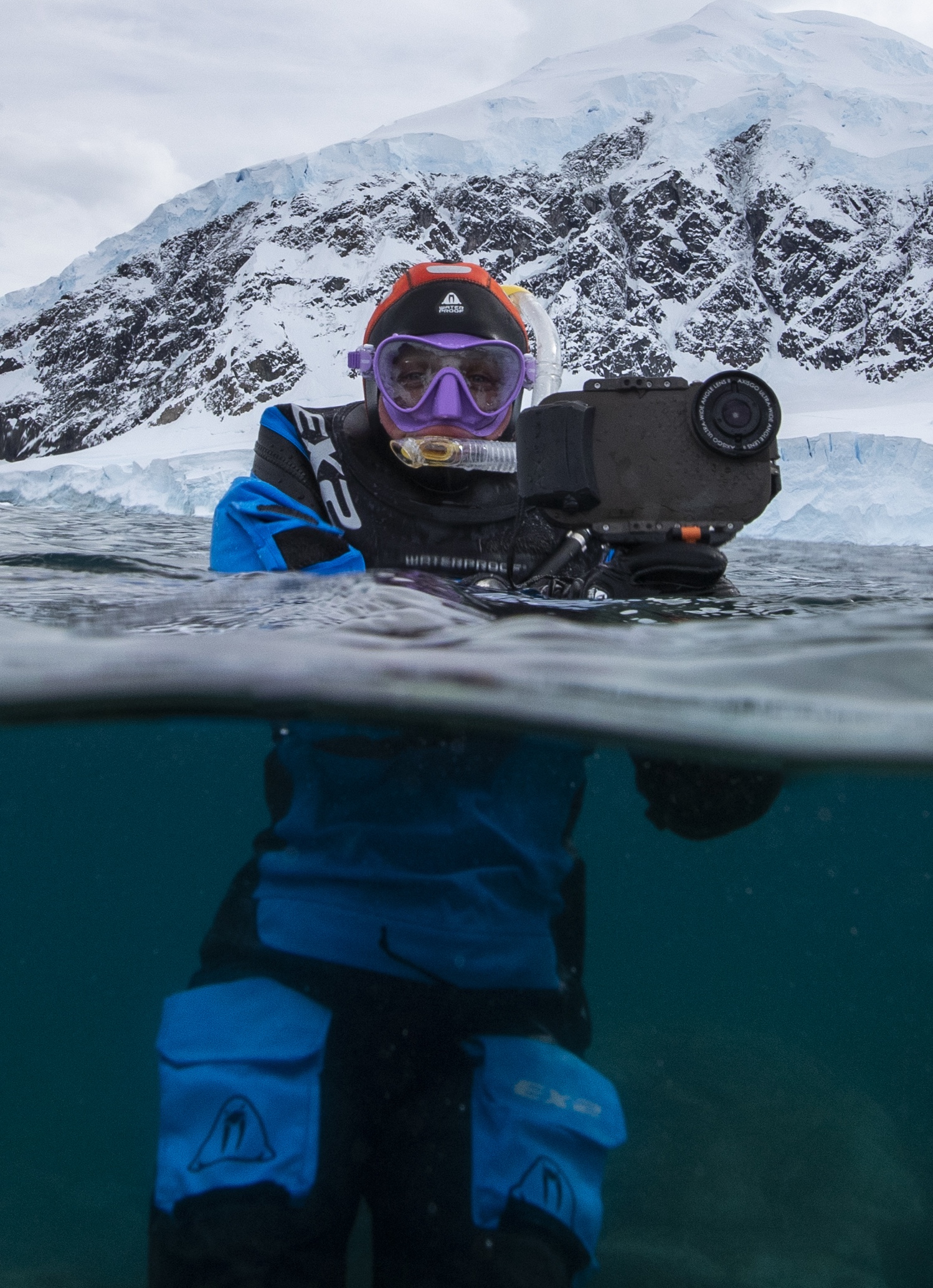 Snorkeller with a camera smiles at camera, Antarctica