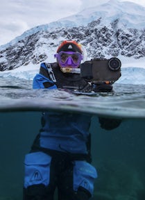 Snorkeller with a camera smiles at camera, Antarctica