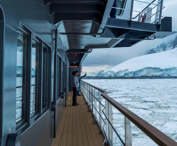 Two people on the balcony of Magellan Explorer, Antarctic expedition vessel in Antarctica