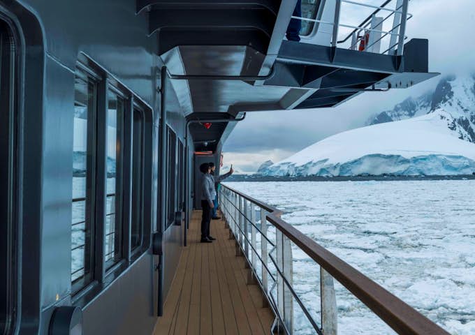 Two people on the balcony of Magellan Explorer, Antarctic expedition vessel in Antarctica