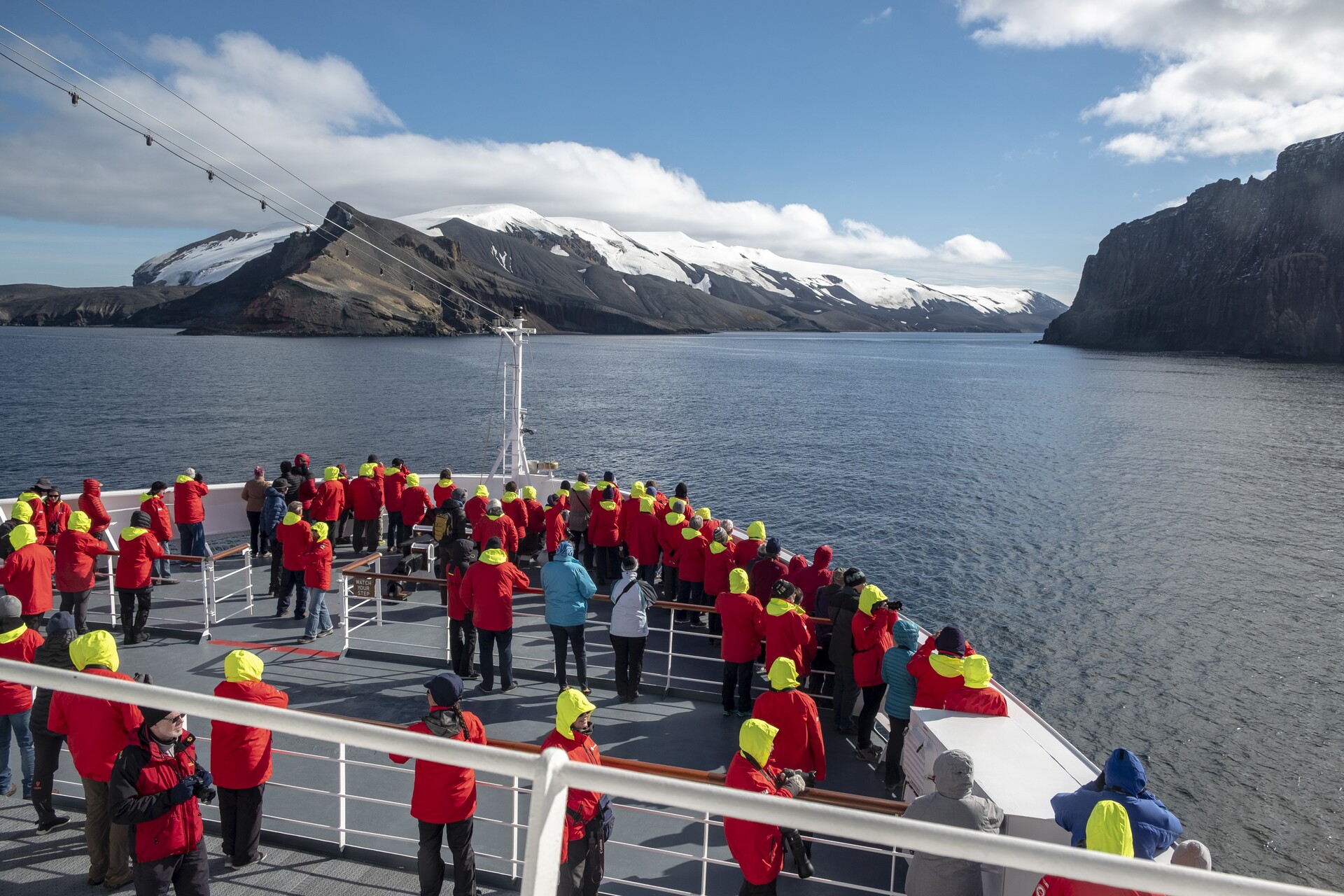 People stand out on deck at Whalers Bay in Antarctica