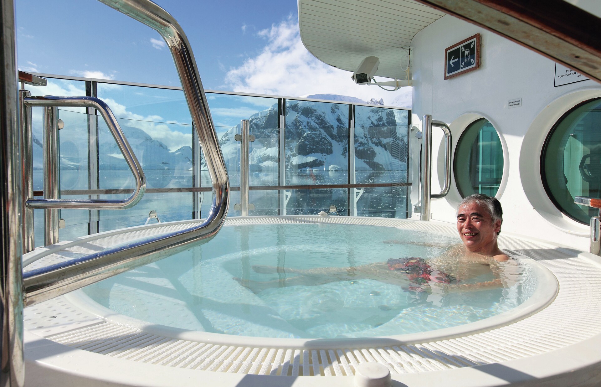 A man enjoys the hot tub and views on an Antarctic cruise ship 