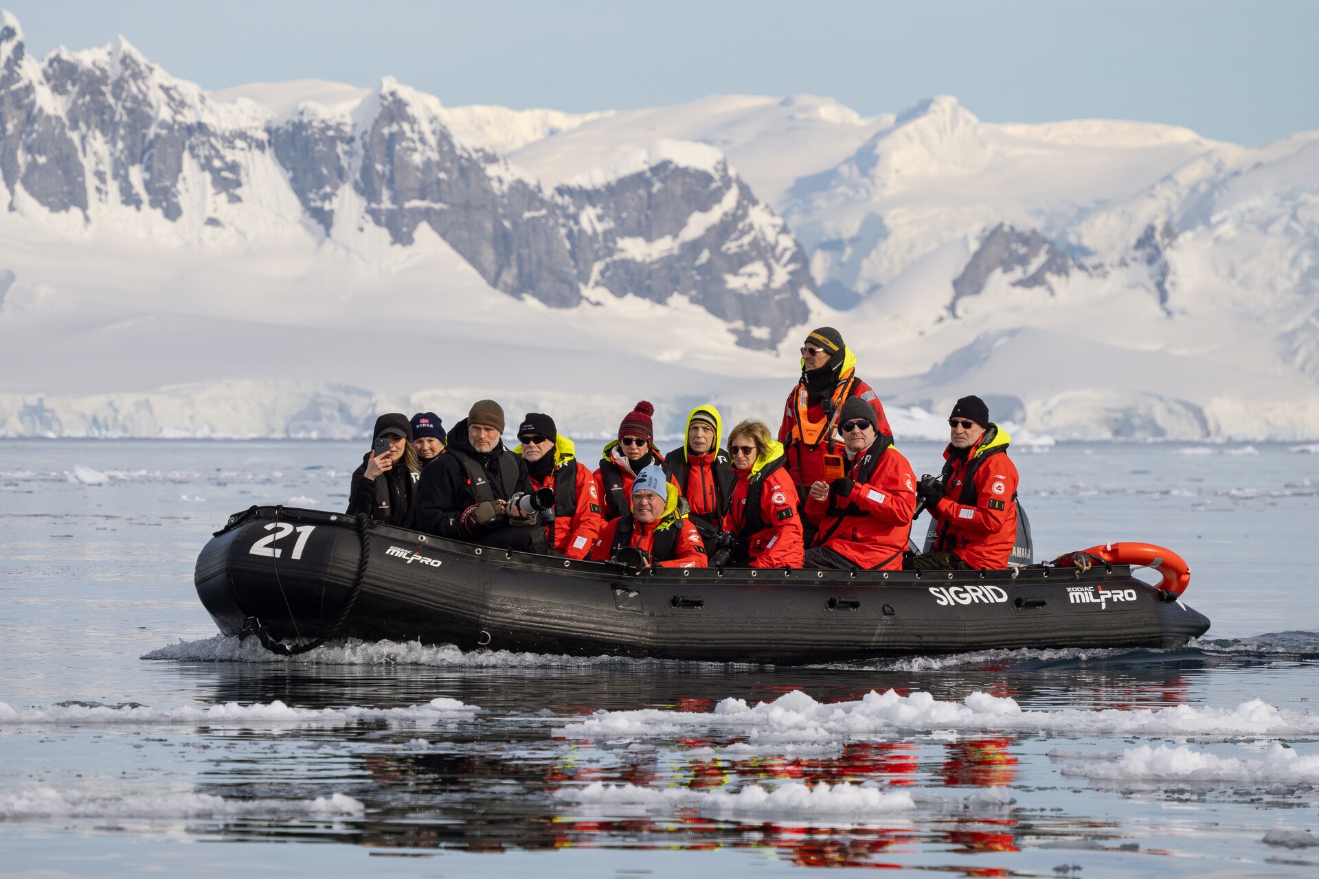 A group of cruise travellers explore Antarctic waters in a zodiac rib boat 