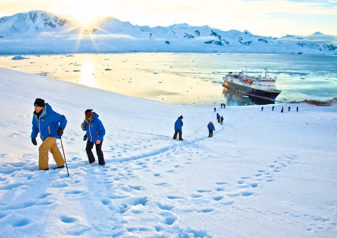 Travellers walk through the snow at Neko Harbour, Antarctica