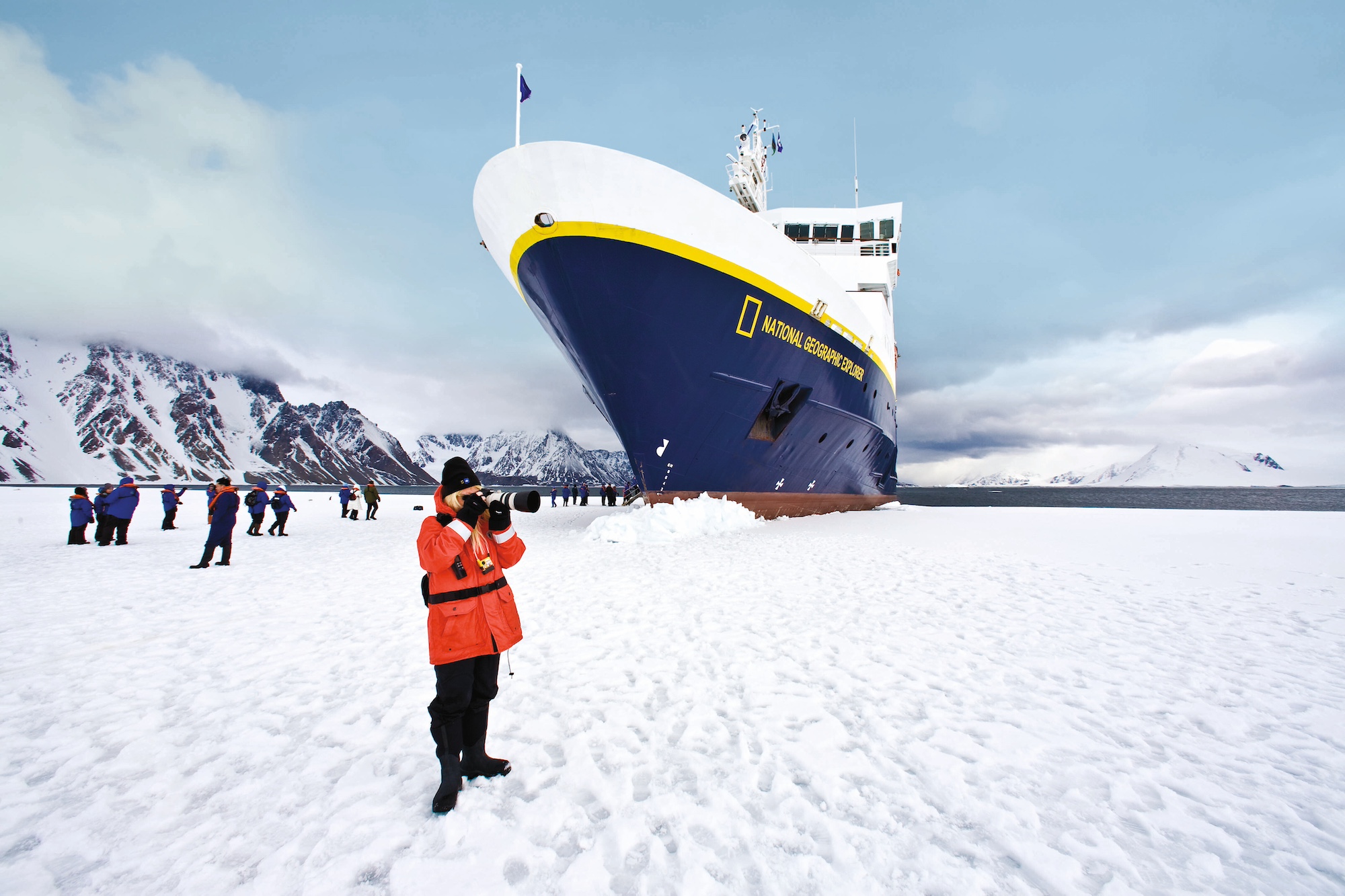 Guests taking photographs outside the ship National Geographic Explorer in Antarctica.