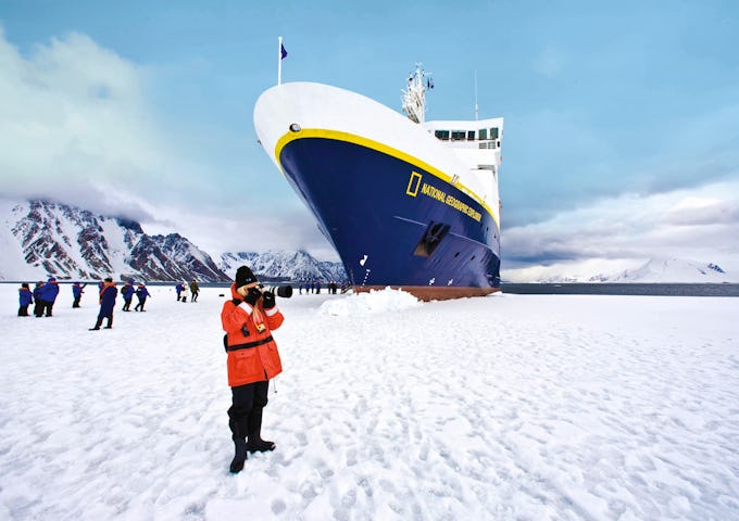 Guests taking photographs outside the ship National Geographic Explorer in Antarctica.
