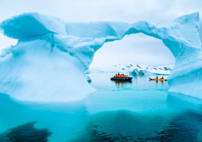 Guests cruise around icebergs by zodiac boat in Antarctica