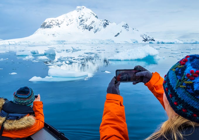 Passengers take photos of icebergs in Paradise Harbour, Antarctica