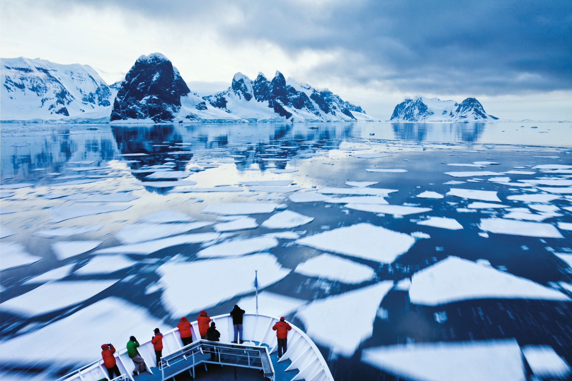Crew navigates the National Geographic Explorer through pack ice in the Lemaire Channel, Antarctica