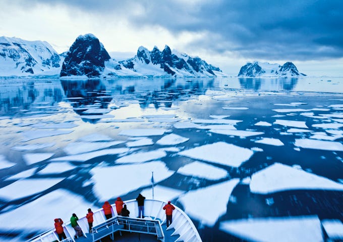 Crew navigates the National Geographic Explorer through pack ice in the Lemaire Channel, Antarctica