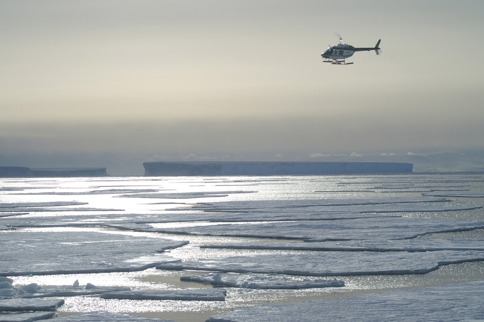 A helicopter flies above the Weddell Sea in Antarctica