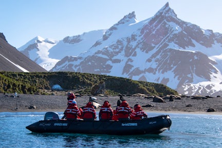 A zodiac with tourists with cruising in Right Whale Bay in South Georgia