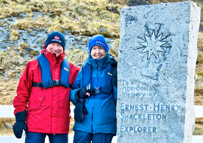 Two tourists by Shackleton's grave at Grytviken in South Georgia