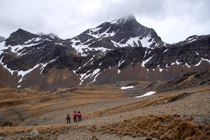 Three tiny figures are dwarfed by the snowy mountains around Mount Duse in Grytviken, South Georgia