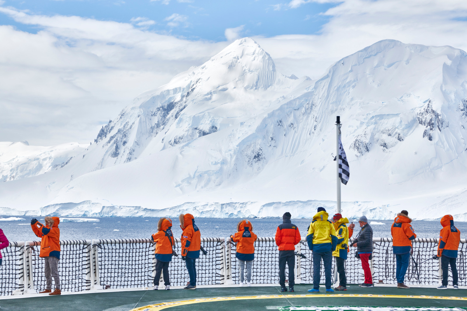 Travellers stand out on deck taking in icy views of the Gullet Channel in Antarctica
