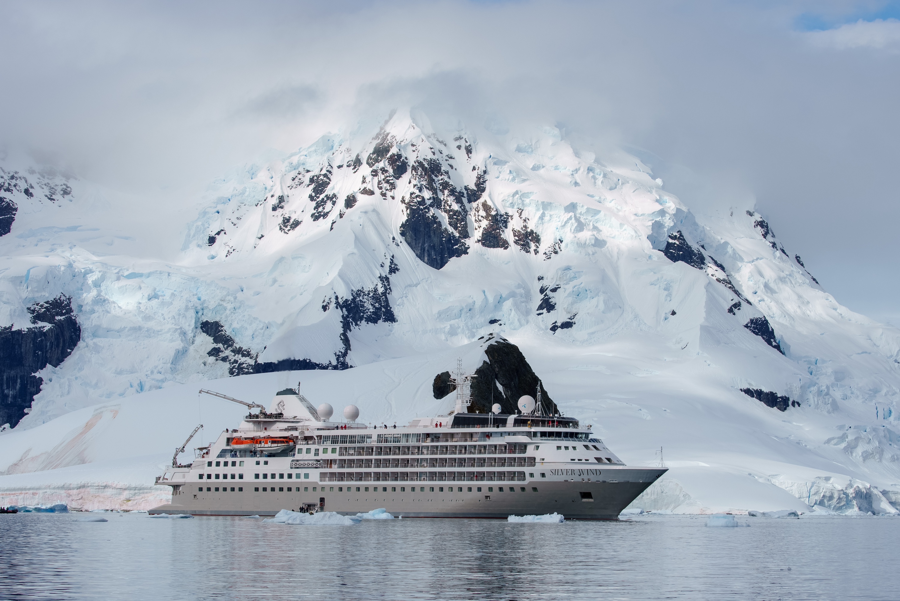 The Silver Wind, an Antarctic ship, sails past a snowy mountain