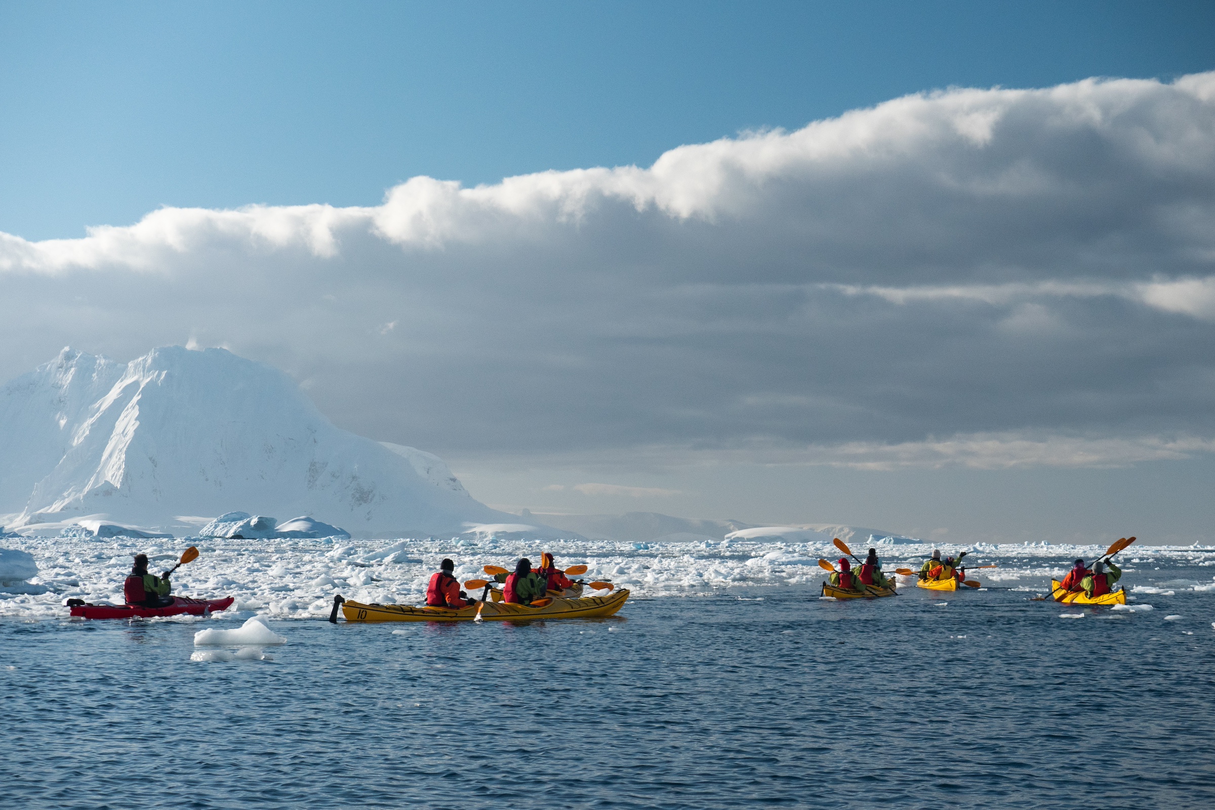 Kayakers paddle among the ice in Antarctica 