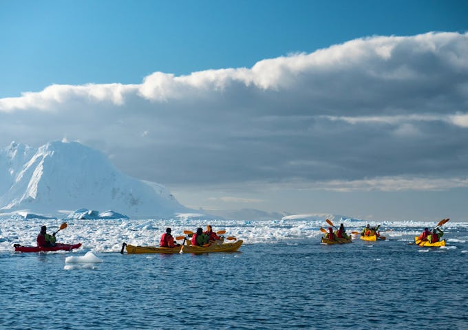 Kayakers paddle among the ice in Antarctica