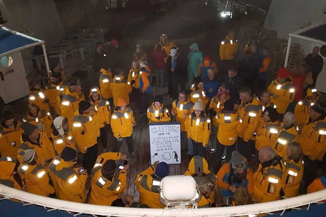 Tourists celebration crossing the Antarctic Circle