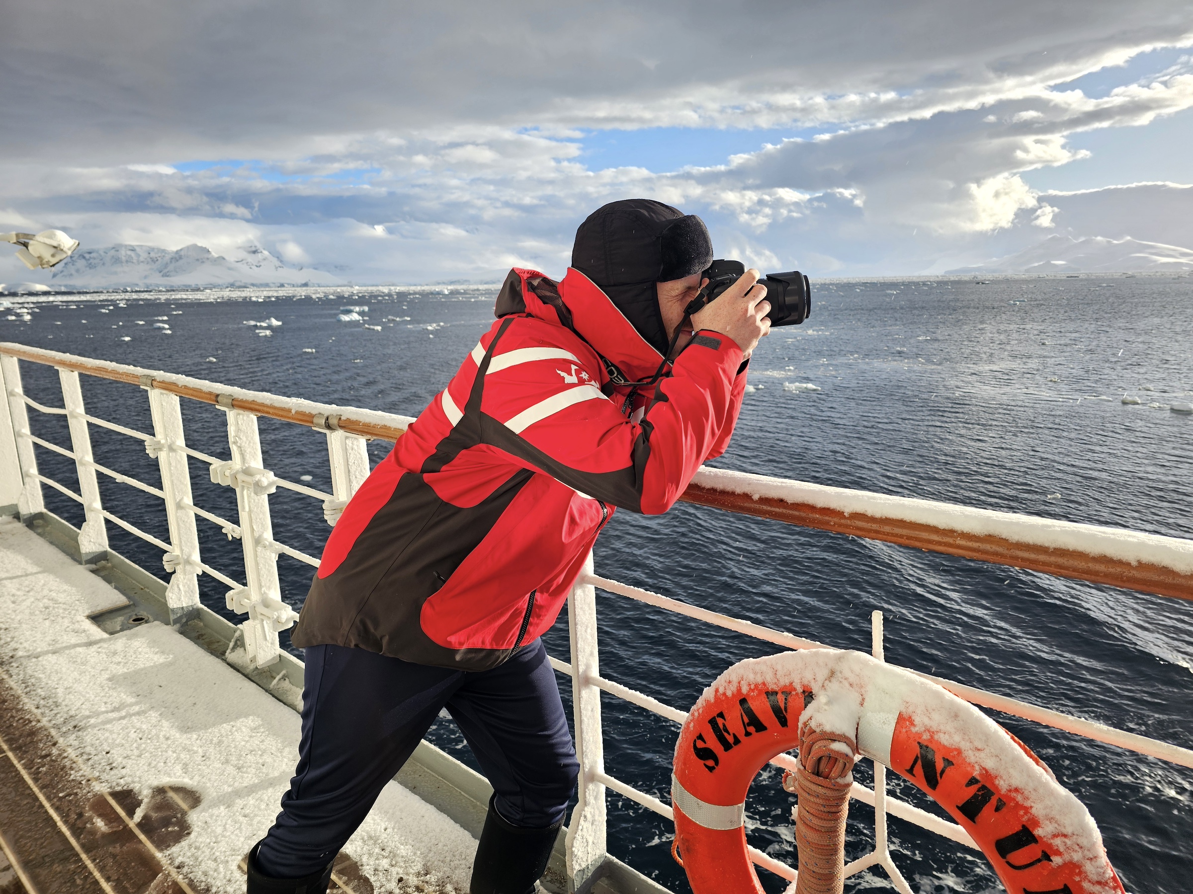 Colin from Swoop takes a photo of Antarctica from out on the deck of a ship 