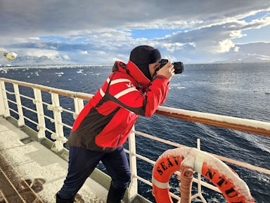 Colin from Swoop takes a photo of Antarctica from out on the deck of a ship