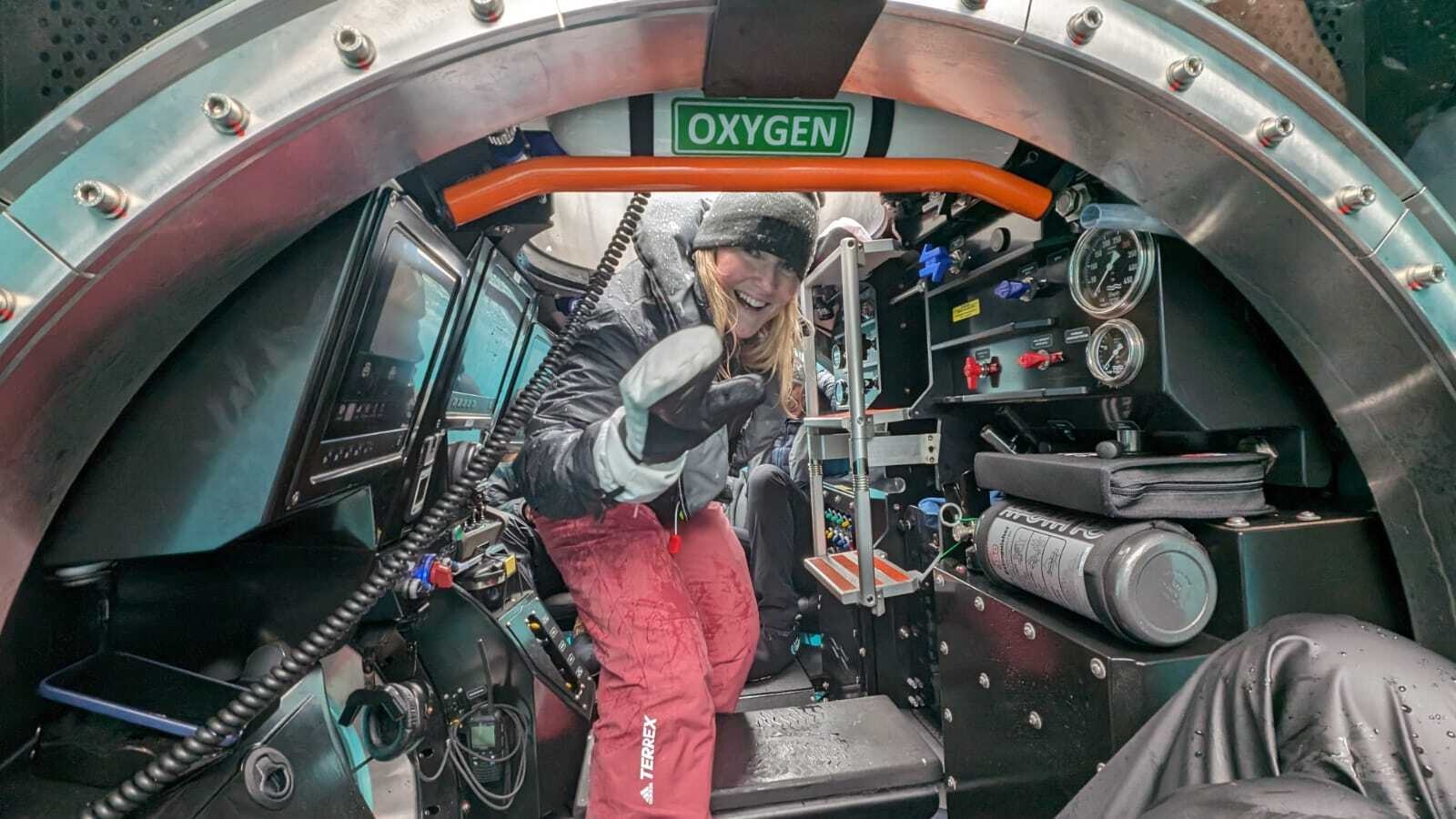 A women waves as she enters a submarine in Antarctica