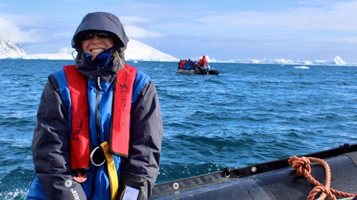 A woman wraps up on a zodiac ride in Antarctica