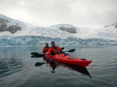 Two men kayak in Antarctica