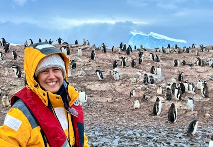 Tourist selfie in front of a gentoo penguin colony in Antarctica in March
