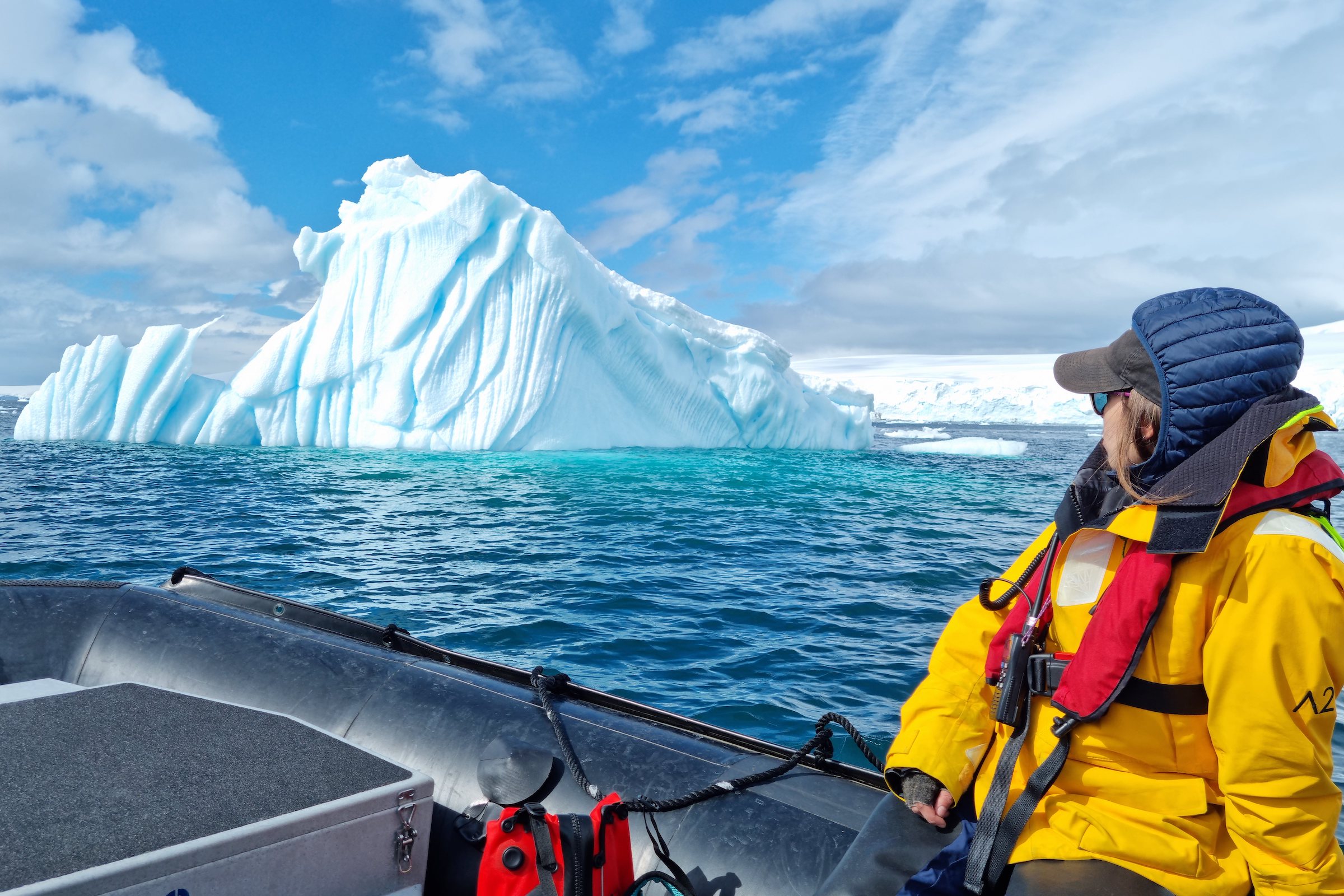 Zodiac cruising by an iceberg in Fournier Bay