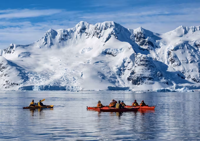 A group of tourists paddling in kayaks off Pleneau Island in the Antarctic Peninsula