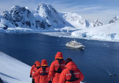 Walking to a viewpoint on the Antarctic Peninsula above Silver Endeavour luxury cruise ship