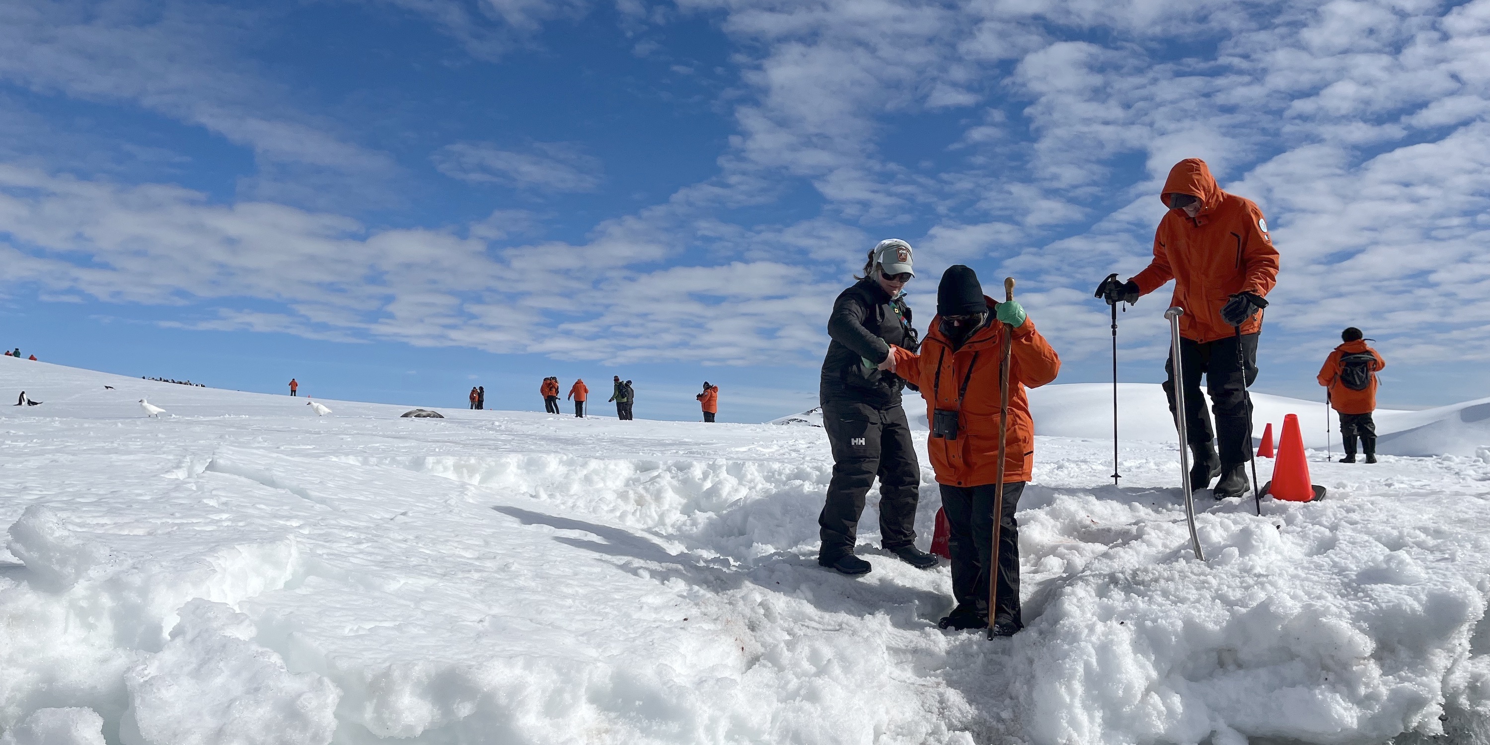 Guide helping a tourist in Antarctica