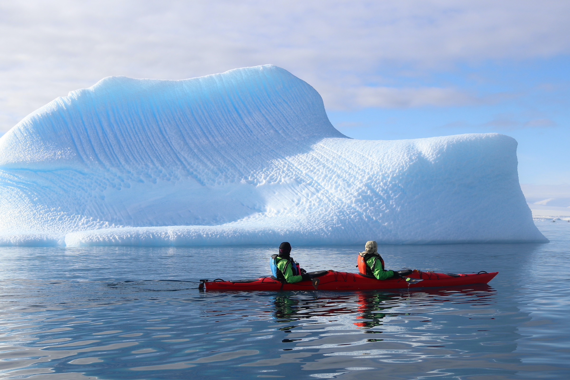 Kayaking in front of an iceberg in Antarctica
