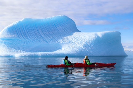 Kayaking in front of an iceberg in Antarctica