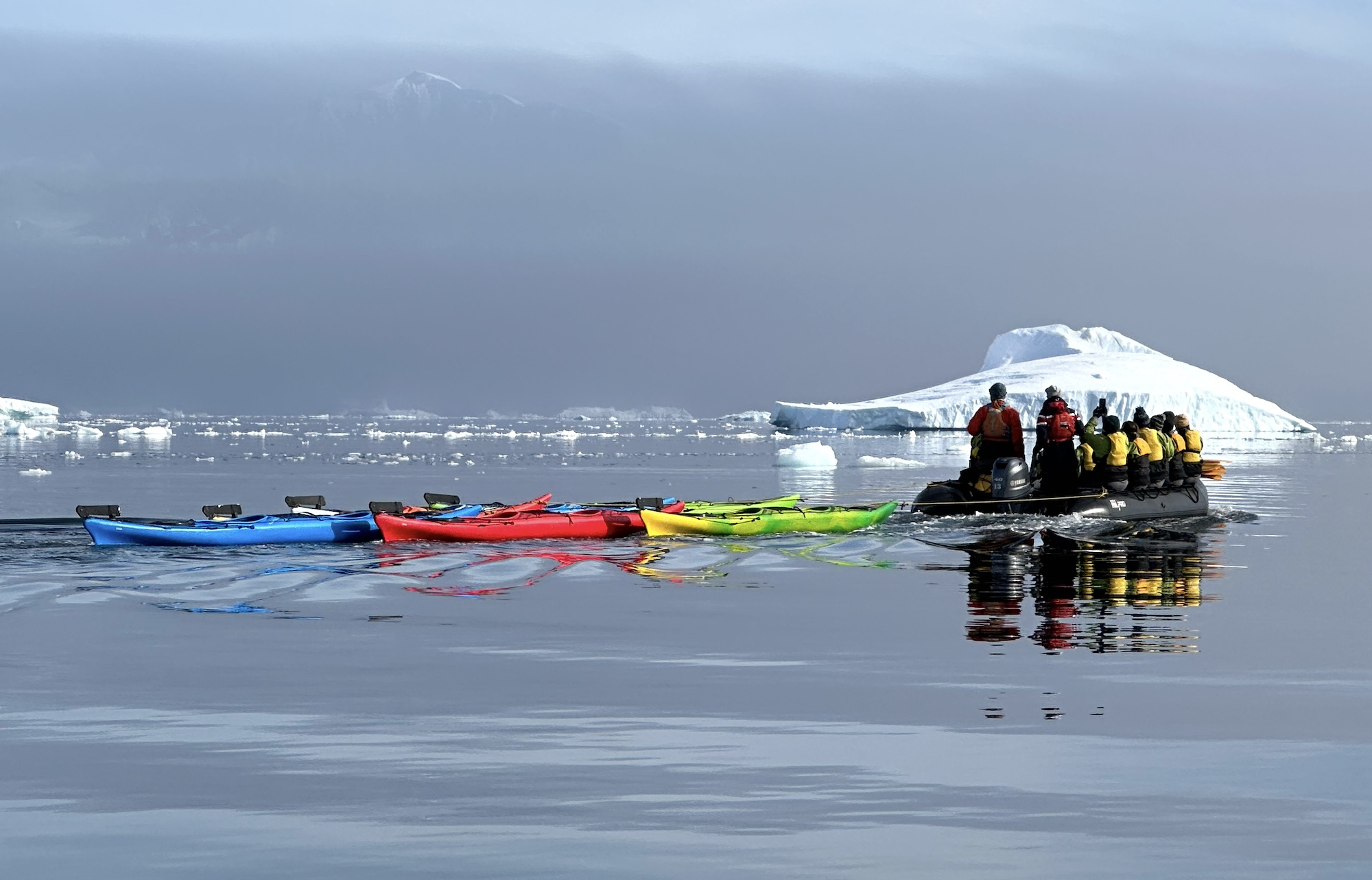 Kayaks are towed at Cuverville Island, Antarctica, in December