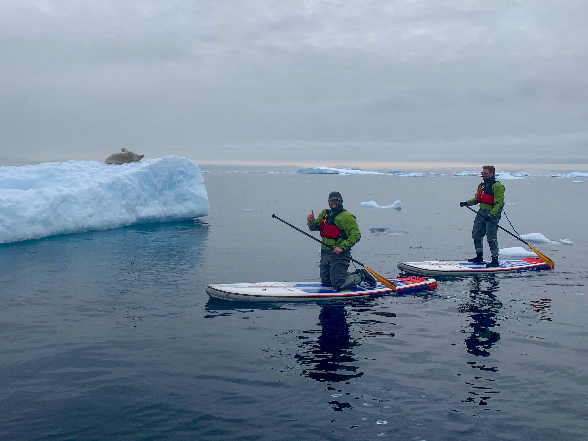 Two men paddleboard in Antarctica 