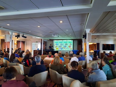 A group of tourists on a cruise ship listen to a mandatory biosecurity presentation before they arrive in Antarctica.