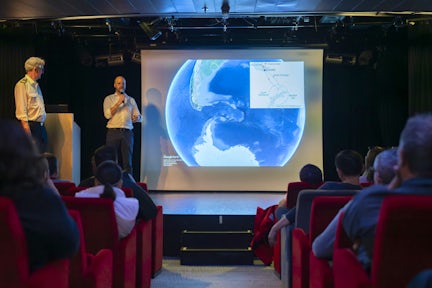 Guide giving an onboard lecture during an Antarctic cruise