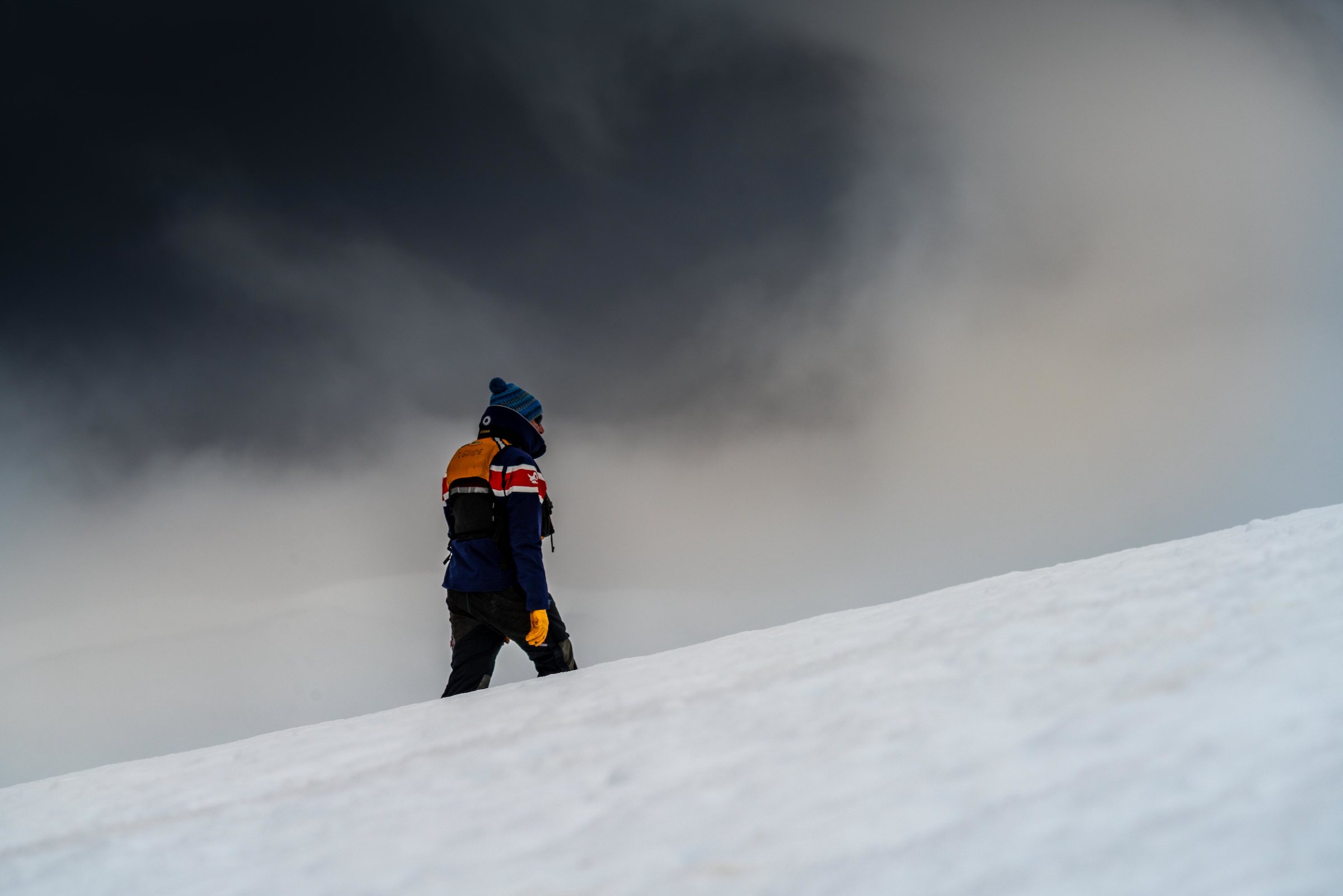 Expedition guide walking through snow in Antarctica in bad weather