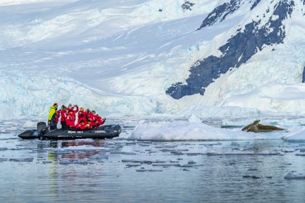 Zodiac cruising past an ice floe with crabeater seals