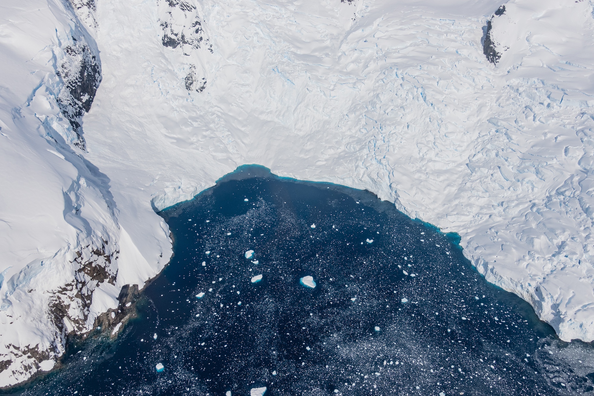 A bird's eye view of an icy bay taken from a helicopter while flightseeing in Antarctica