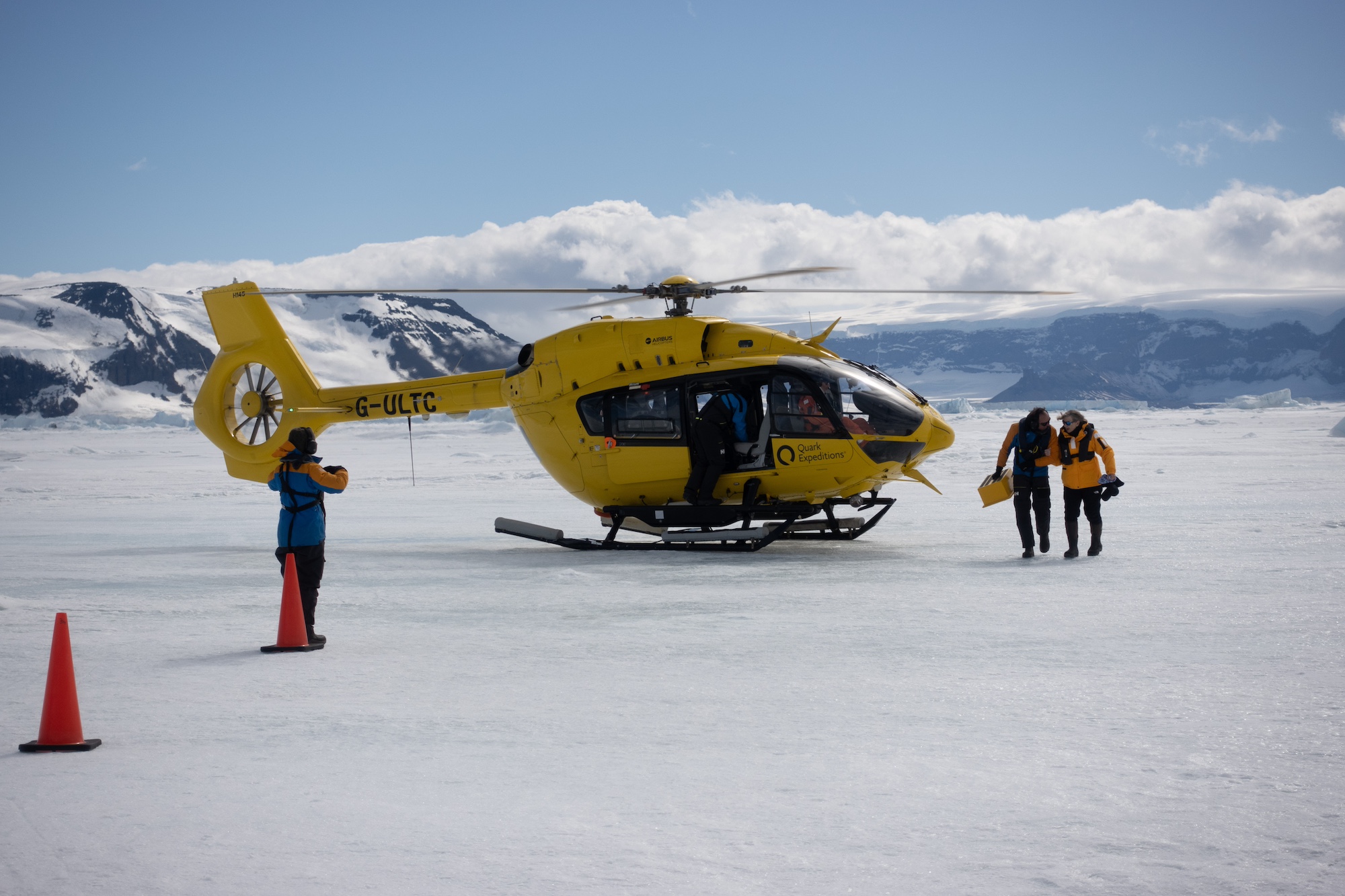 A bright yellow helicopter sits on the Antarctic Continent 
